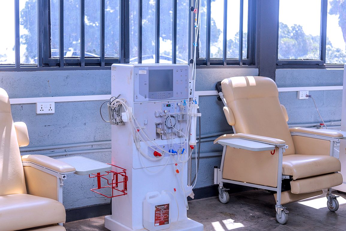 A dialysis machine primed for treatment, between two treatment chairs in the renal unit at SAS Lweza Clinic